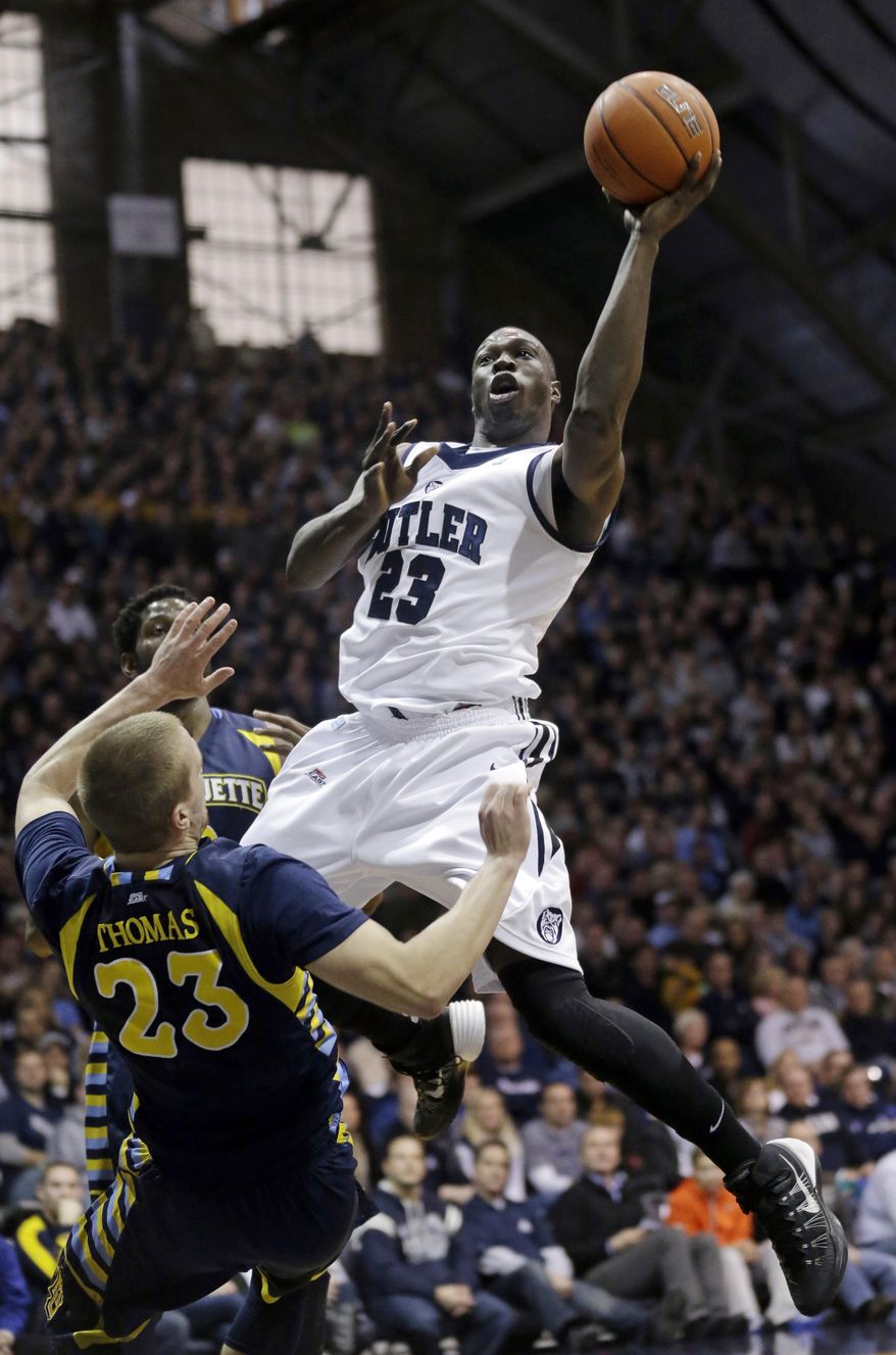 Marquette guard Jake Thomas, left, draws the charge from Butler forward Khyle Marshall in the first half of an NCAA college basketball game in Indianapolis, Saturday, Jan. 18, 2014. (AP Photo/Michael Conroy)