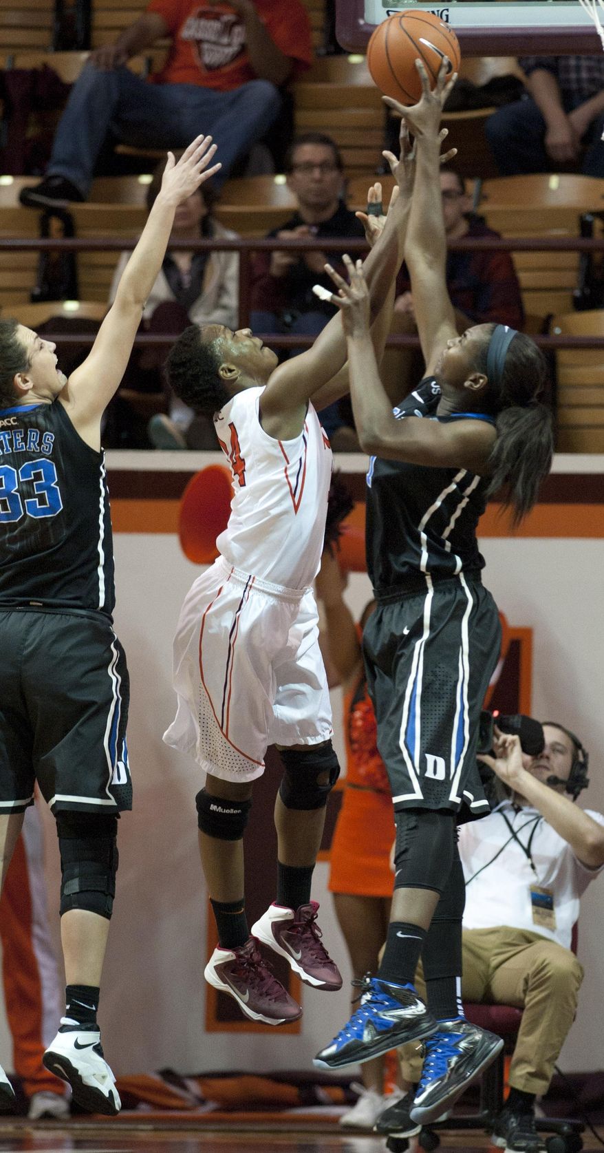Duke's Elizabeth Williams, right, blocks the shot of Virginia Tech's Uju Ugota during the first half of an NCAA women's college basketball game, Sunday, Jan. 19, 2014, in Blacksburg, Va. (AP Photo/Don Petersen)