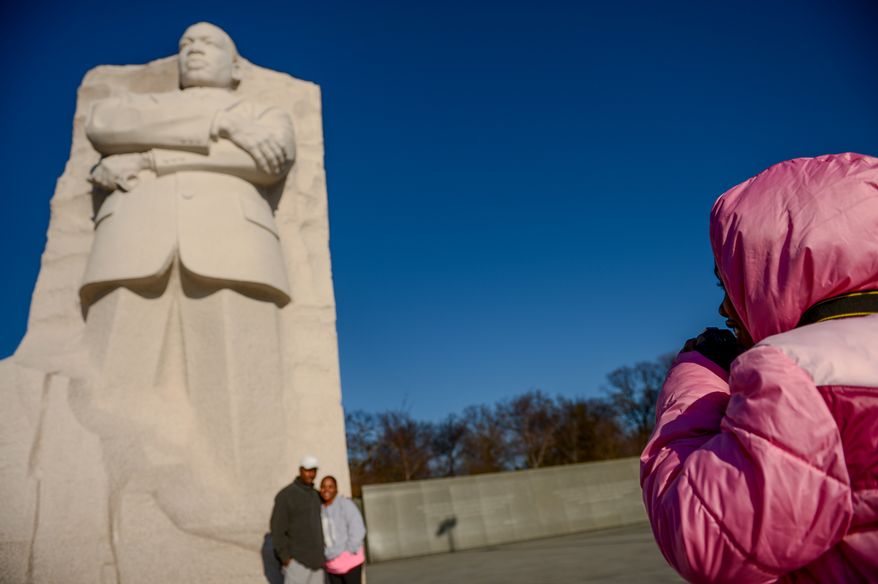 Aliya Logan, 8, right, of Virginia Beach, Va., photographs her parents, Gerald and Lisa in front of the Martin Luther King, Jr. Memorial a day before Martin Luther King Jr. Day, Washington, D.C., Sunday, January 19, 2014. (Andrew Harnik/The Washington Times)