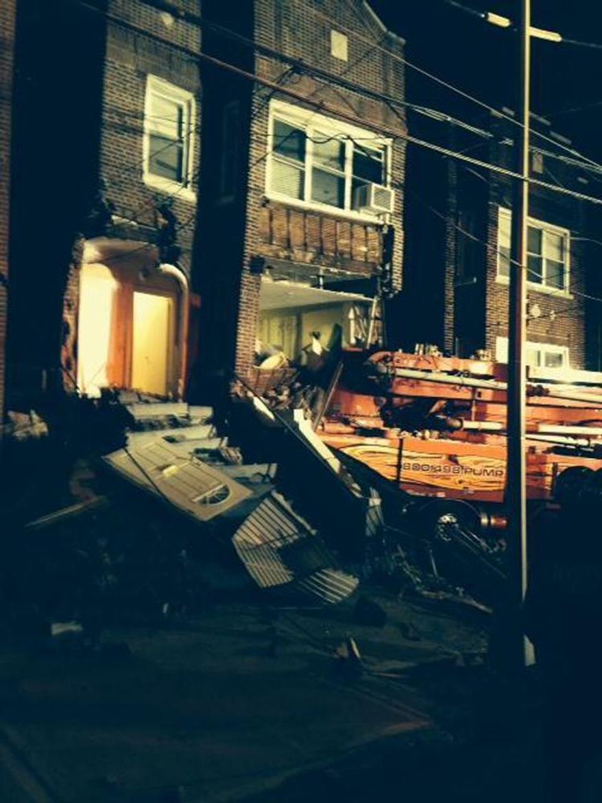 This photo provided by the New York City Fire Department shows a cement truck that slammed into a 3-story home in the Bronx borough of New York, Monday, Jan. 20, 2014. Officials say the driver of the truck was killed and several other people were injured. (AP Photo/New York City Fire Department)