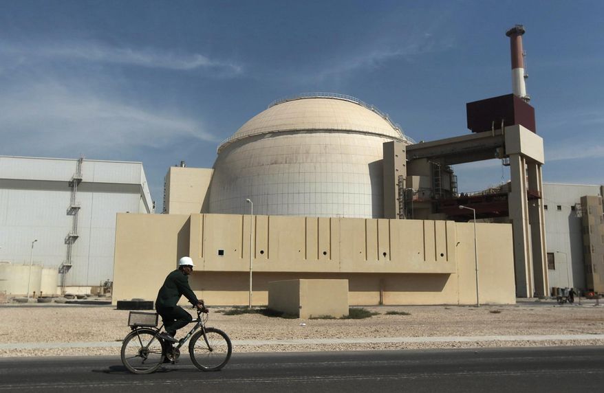 FILE - In this Oct. 26, 2010 file photo, a worker rides a bicycle in front of the reactor building of the Bushehr nuclear power plant, just outside the southern city of Bushehr, Iran. Ahead of the start of a nuclear deal between Iran and world powers, an official in the Islamic Republic has called limiting uranium enrichment and diluting its stockpile the country’s “most important commitments.” (AP Photo/Mehr News Agency, Majid Asgaripour, File)