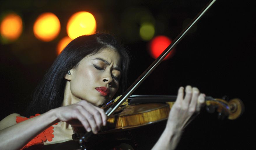 FIL:E - This is a Monday, Oct. 18, 2010 file photo of Internationally renown violinist Vanessa Mae as she performs during her concert in Prague, Czech Republic. The manager of musician Vanessa Mae says the musician will be swapping her violin for skis to compete at the Winter Olympics. Giles Howard says the classical-pop violinist has qualified for the Thai team at the Sochi games. The International Ski Federation published rankings on Monday Jan. 20, 2014 confirming Mae has met the qualifying criteria to compete at Sochi. (AP Photo/CTK, Rene Volfik) ** SLOVAKIA OUT **