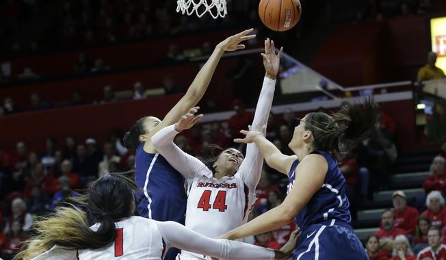Rutgers forward Betnijah Laney (44) takes a shot as she splits Connecticut defenders Kiah Stokes and Stefanie Dolson, right, during the first half of an NCAA college basketball game Sunday, Jan. 19, 2014, in Piscataway, N.J. (AP Photo/Mel Evans)