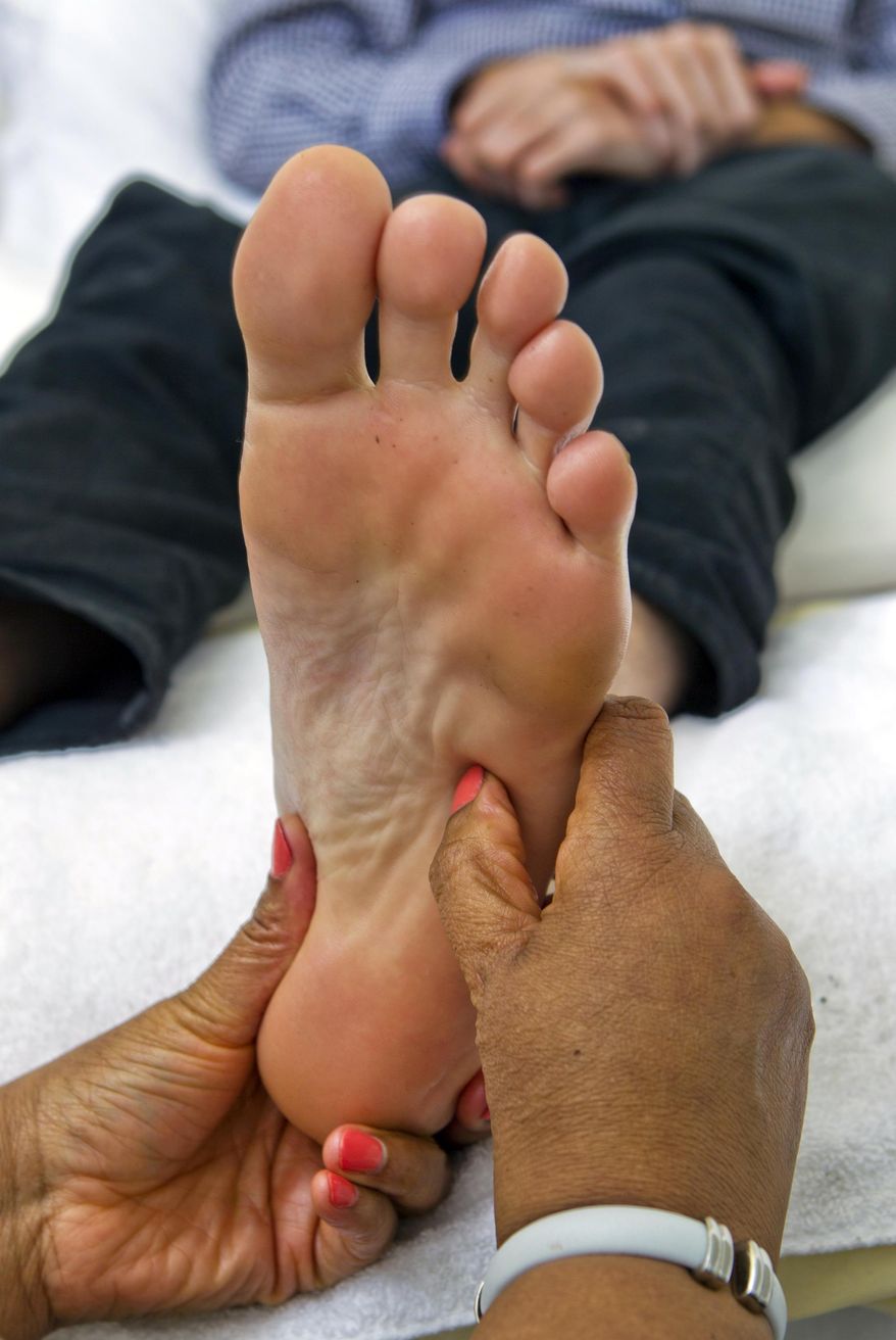 In this Friday, Jan. 17, 2014, photo, Wendy Dearborne, a reflexologist with the Adassa James Institute, gives a foot massage. Clark County officials are drafting regulations on reflexology businesses, hoping to weed scammers and prostitution out of the large but minimally regulated foot massage industry. The proposed changes set for a commission vote next month would add a new chapter in the county code to address reflexology, a practice that involves putting pressure on the feet, hands or ears to achieve a variety of health benefits. (AP Photo/The Las Vegas Sun, L.E. Baskow) LAS VEGAS REVIEW-JOURNAL OUT