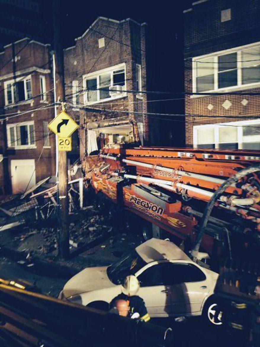 This photo provided by the New York City Fire Department shows a cement truck that slammed into a 3-story home in the Bronx borough of New York, Monday, Jan. 20, 2014. Officials say the driver of the truck was killed and several other people were injured. (AP Photo/New York City Fire Department)