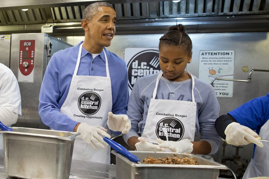 President Barack Obama and his daughter Sasha, right, make burritos at DC Central Kitchen as part of a service project in honor of Martin Luther King, Jr. Day, Monday, Jan. 20, 2014, in Washington. Also helping were first lady Michelle Obama and daughter Malia Obama. (AP Photo/Jacquelyn Martin)