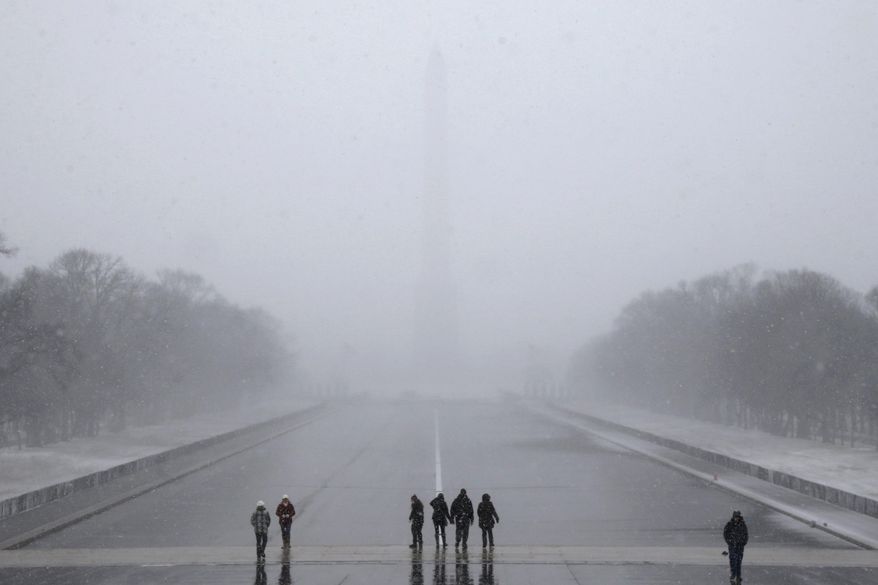 The Washington Monument is barely visible from the Lincoln Memorial as snow falls in Washington, Tuesday, Jan. 21, 2014. Many government offices and schools closed before the first flake of snow, but there were signs Tuesday that significant winter weather was moving into the mid-Atlantic region as heavy snow began falling. (AP Photo/Charles Dharapak)