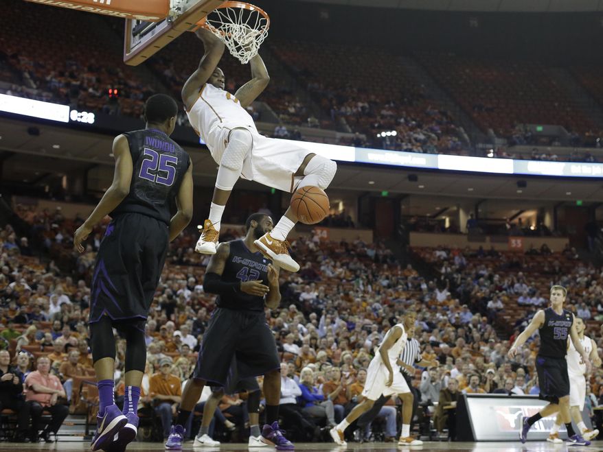 Texas' Prince Ibeh (44) scores over Kansas State's Wesley Iwundu (25) and Thomas Gipson (42) during the first half of an NCAA college basketball game, Tuesday, Jan. 21, 2014, in Austin, Texas. (AP Photo/Eric Gay)