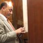 State Rep. Les Gara, D-Anchorage, checks his cell phone in the foyer during a break, Tuesday, Jan. 21, 2014, during a break from the opening session of the Alaska House of Representatives in Juneau, Alaska. (AP Photo/Mark Thiessen)