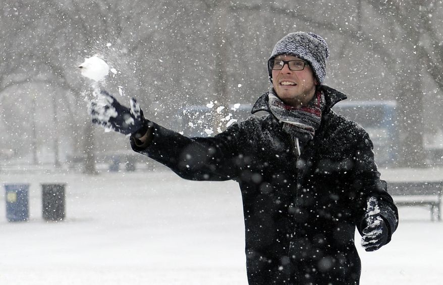 Rick Mendenhall, of Albuquerque, N.M., throws a snowball during a snowball fight with his friends on the National Mall in Washington during the start of a major snowstorm, Tuesday, Jan. 21, 2014. Many government offices and schools closed before the first flake of snow, but there were signs Tuesday that significant winter weather was moving into the Mid-Atlantic region as heavy snow began falling. (AP Photo/Susan Walsh)