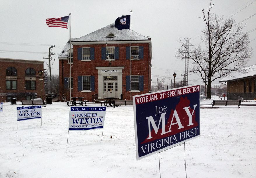 Signs for candidates are seen in the snow outside of Town Hall in Herndon, Va., Tuesday, Jan. 21, 2014. The special election will likely determine which party controls the state Senate. Election officials said they were pleasantly surprised that, despite the nasty weather, turnout could reach 20 percent in some precincts. (AP Photo/Matt Barakat)
