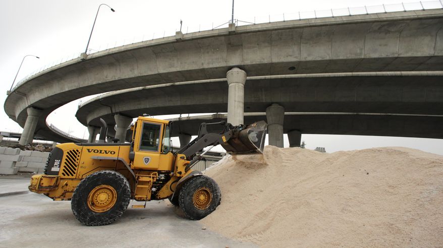 A front end loader piles up a mixture of sand and salt at a loading yard at the Mass. Dept. of Conservation and Recreation in advance of an expected winter snow storm Tuesday, Jan. 21, 2014, in Cambridge, Mass. The Boston area is expected to get about a foot of snow by Wednesday evening. (AP Photo/Charles Krupa)