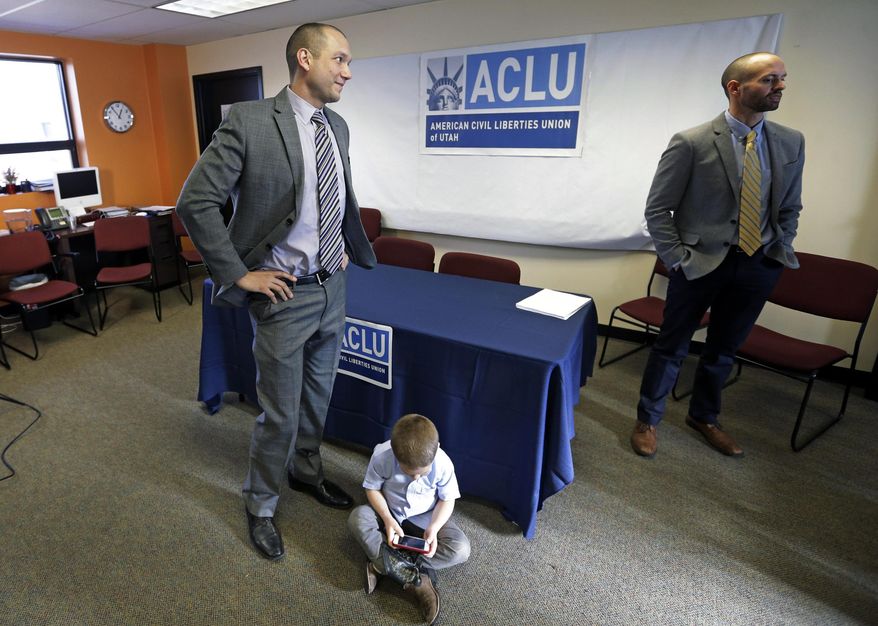 Plaintiffs Matthew Barraza, left, and his husband Tony Milner, right, look on as their son Jesse, 4, plays, following a news conference on Tuesday, Jan. 21, 2014, in Salt Lake City. The American Civil Liberties Union has sued the state of Utah over the issue of gay marriage, saying the official decision to stop granting benefits for newly married same-sex couples has created wrenching uncertainty. The lawsuit filed Tuesday says the state has put hundreds of gay and lesbian couples in legal limbo and prevented them from getting key protections for themselves and their children. (AP Photo/Rick Bowmer)