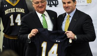 Jack Swarbrick, left, Notre Dame Vice President and Director of Athletics, left, and Kevin Plank, CEO and founder of Under Armour, hold up a jersey during a news conference Tuesday Jan. 21, 2014, in South Bend, Ind., announcing an agreement between Notre Dame and Under Armour that will outfit the university&#39;s athletic teams  (AP Photo/Joe Raymond)