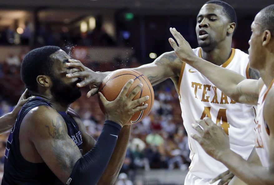 Kansas State's Thomas Gipson, left, takes a foul to the face from Texas' Prince Ibeh (44)during the second half of a NCAA college basketball game, Tuesday, Jan. 21, 2014, in Austin, Texas. Texas won 67-64. (AP Photo/Eric Gay)