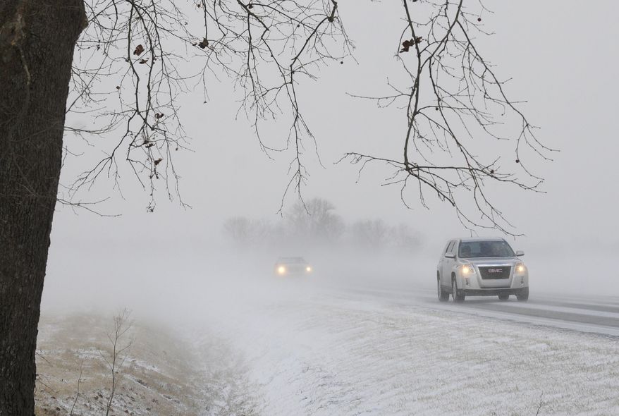An icy road, frigid temperatures and wind blown snow makes for near blizzard conditions for morning drivers along state road 136 west Tuesday morning, Jan. 21, 2014, in Henderson County, Ky. Snow and wind brought hazardous winter conditions to a large swath of Kentucky on Tuesday, creating a slow, messy morning commute and previewing a drop in temperatures to the single digits and teens as the week wears on. (AP Photo/The Gleaner, Mike Lawrence)