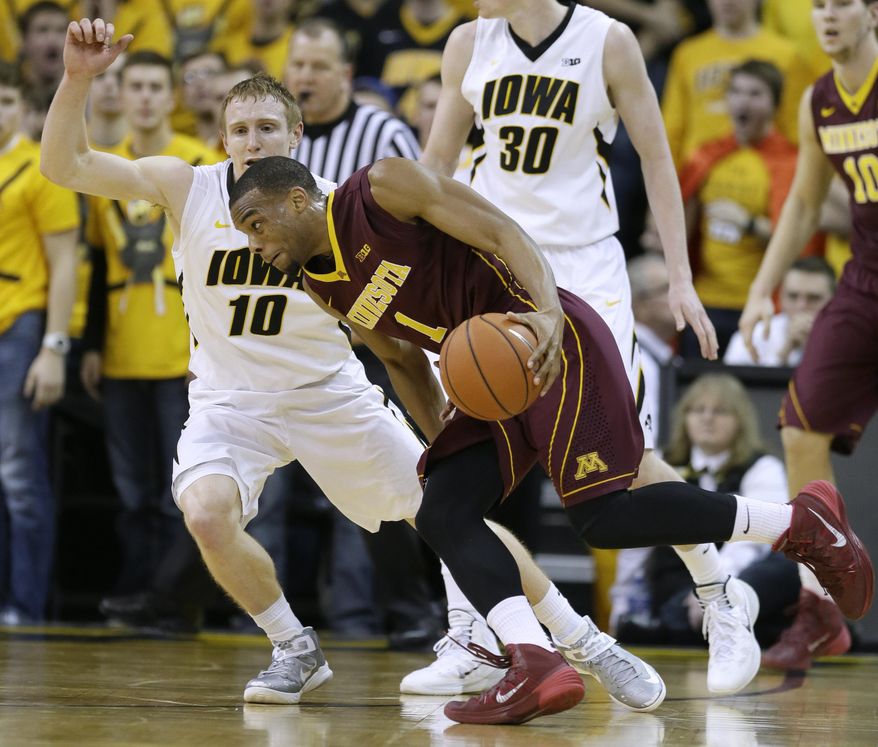 Minnesota guard Andre Hollins, right, drives past Iowa guard Mike Gesell (10) during the second half of an NCAA college basketball game, Sunday, Jan. 19, 2014, in Iowa City, Iowa. Iowa won 94-73. (AP Photo/Charlie Neibergall)