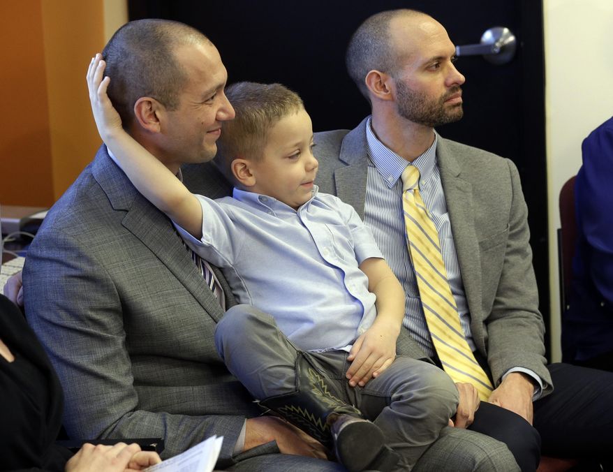 Plaintiffs Matthew Barraza, left, and his husband Tony Milner, right, look on as they hold their son Jesse, 4, during a news conference, Tuesday, Jan. 21, 2014, in Salt Lake City. The American Civil Liberties Union has sued the state of Utah over the issue of gay marriage, saying the official decision to stop granting benefits for newly married same-sex couples has created wrenching uncertainty. The lawsuit filed Tuesday said the state has put hundreds of gay and lesbian couples in legal limbo and prevented them from getting key protections for themselves and their children. (AP Photo/Rick Bowmer)