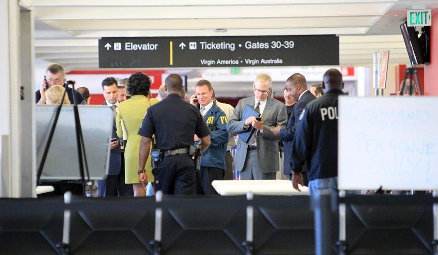 FILE - In this Nov. 1, 2013 file photo, federal and local investigators gather in Terminal 3 at Los Angeles International Airport where a gunman armed with a semi-automatic rifle opened fire, killing a Transportation Security Administration employee and wounding two other people. Two armed police officers, not seen in this photo, assigned to guard the terminal, left for breaks without informing dispatchers as required minutes before the gunfire erupted. (AP Photo/Ringo H.W. Chiu, File)