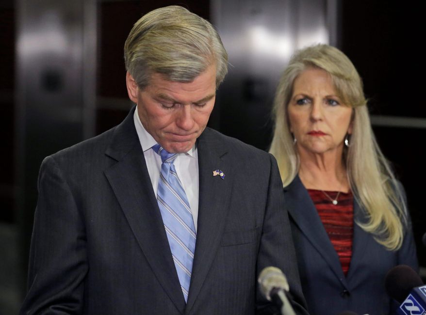 Former Virginia Gov. Bob McDonnell pauses while making a statement as his wife, Maureen, right, listens during a news conference in Richmond, Va., Tuesday, Jan. 21, 2014. McDonnell and his wife were indicted Tuesday on corruption charges after a monthslong federal investigation into gifts the Republican received from a political donor. (AP Photo/Steve Helber)