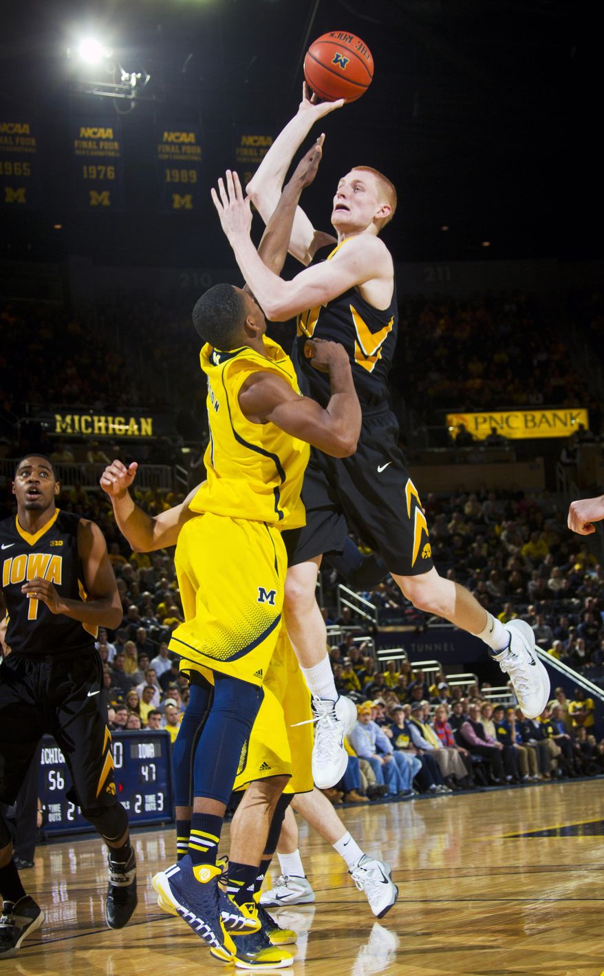 Iowa forward Aaron White, top, attempts a shot over Michigan forward Glenn Robinson III, in the second half of an NCAA college basketball game in Ann Arbor, Mich., Wednesday, Jan. 22, 2014. Michigan won 75-67. (AP Photo/Tony Ding)