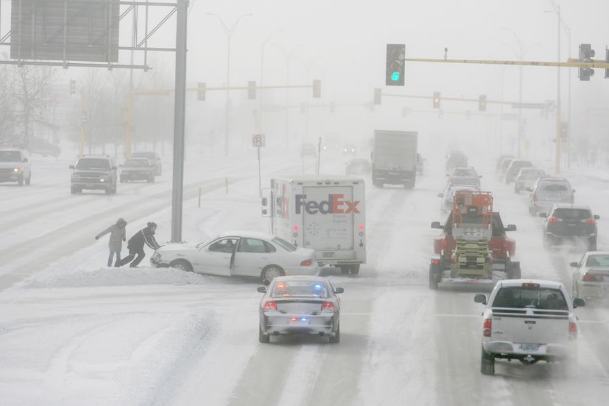 Fargo Police attend to an accident on University Drive at Interstate 94 on Wednesday, Jan. 22, 2014 in South Fargo, N.D. Some schools and offices closed Wednesday and motorists struggled to get to their destinations as the second blizzard in less than a week tore through the Red River Valley of eastern North Dakota. The National Weather Service issued a blizzard warning for eastern North Dakota through Wednesday afternoon. Transportation officials early Wednesday advised motorists to use caution in eastern and south central North Dakota. A no-travel advisory was issued for northeastern North Dakota but lifted midmorning. (AP Photo/Bruce Crummy)