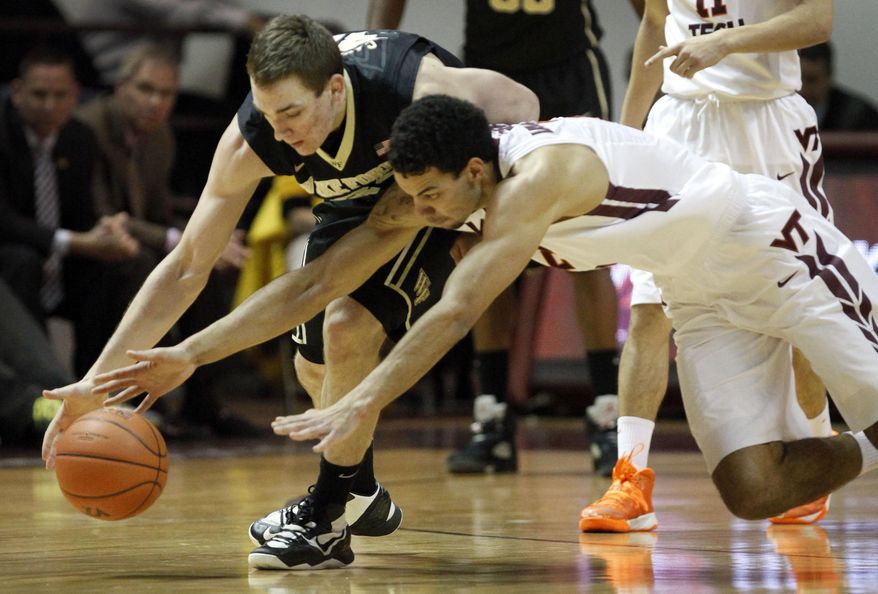 Virginia Tech's Joey van Zegeren, right, dives for a loose ball next to Wake Forest's Tyler Cavanaugh during the second half of an NCAA college basketball game in Blacksburg, Va., Wednesday, Jan. 22 2014. Wake Forest won 83-77. (AP Photo/The Roanoke Times, Matt Gentry)