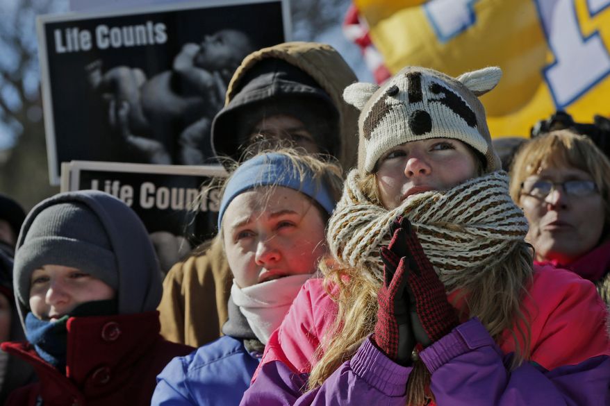 Anne Marie Duty, from Shawnee, Okla., right, joins other anti-abortion demonstrators as they rally during the annual March for Life, Wednesday, Jan. 22, 2014, on the National Mall in Washington. Thousands of anti-abortion demonstrators are gathering in Washington for an annual march to protest the Supreme Court's landmark 1973 decision that declared a constitutional right to abortion. (AP Photo/Charles Dharapak)