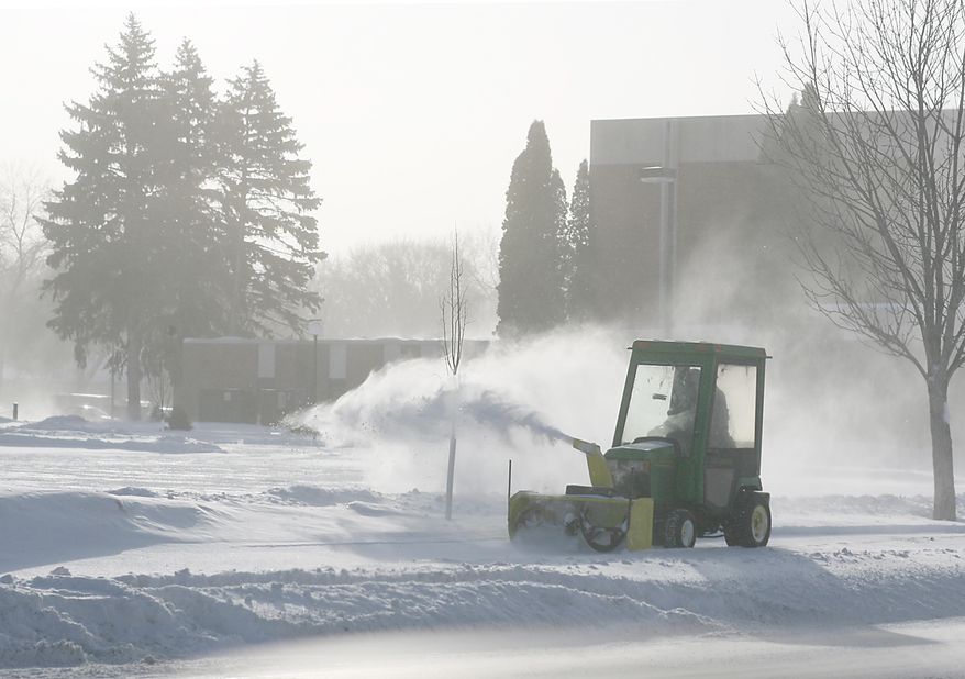 Maintenance crews clears a sidewalk on Wednesday, Jan. 22, 2014 in Fargo, N.D. Some schools and offices closed Wednesday and motorists struggled to get to their destinations as the second blizzard in less than a week tore through the Red River Valley of eastern North Dakota. The National Weather Service issued a blizzard warning for eastern North Dakota through Wednesday afternoon. Transportation officials early Wednesday advised motorists to use caution in eastern and south central North Dakota. A no-travel advisory was issued for northeastern North Dakota but lifted midmorning. (AP Photo/Bruce Crummy)
