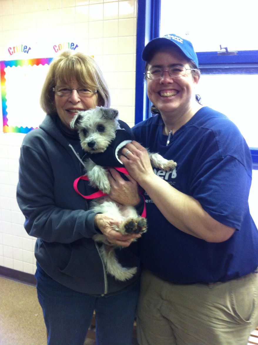 FILE - In this Jan. 12, 2014, photo provided by the American Society for the Prevention of Cruelty to Animals, ASPCA, shows Mary Anne Saunders, left, adopting Josie, a terrier/poodle mix, about 4-5 years old from Melissa Morgan, a kennel attendant and adoption counselor, right, at St. Hubert’s Animal Welfare Center in Madison, N.J. Josie was one of the last of 45 Tennessee dogs adopted when Mary Anne Saunders took her home to live with three cats. The dogs were rounded up at overcrowded shelters in Tennessee and brought to St. Hubert’s in Madison, N.J., which had enough open kennels for all the dogs. (AP Photo/ASPCA)