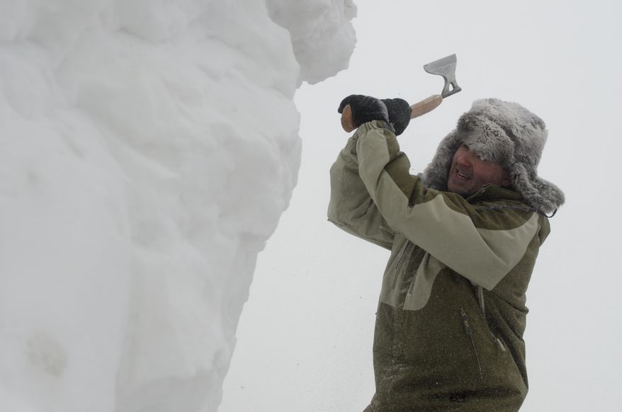 Jason McCullough of Clio, takes chunks of snow and ice off of his sculpture with an axe at the World Class Snow Sculpting Competition at Zehnder's Snowfest in Frankenmuth, Mich., on Wednesday, Jan. 22, 2014. Bitter cold is lingering across Michigan, with readings below zero and more snow forecast for parts of the state. (AP Photo/The Saginaw News, Tim Goessman ) ALL LOCAL TV OUT; LOCAL TV INTERNET OUT