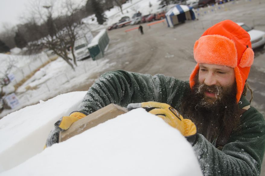 George Mertz, of Payton, Ohio, sculpts the top of his team's snow sculpture at the World Class Snow Sculpting Competition at Zehnder's Snowfest in Frankenmuth, Mich., on Wednesday, Jan. 22, 2014. Bitter cold is lingering across Michigan, with readings below zero and more snow forecast for parts of the state. (AP Photo/The Saginaw News, Tim Goessman ) ALL LOCAL TV OUT; LOCAL TV INTERNET OUT