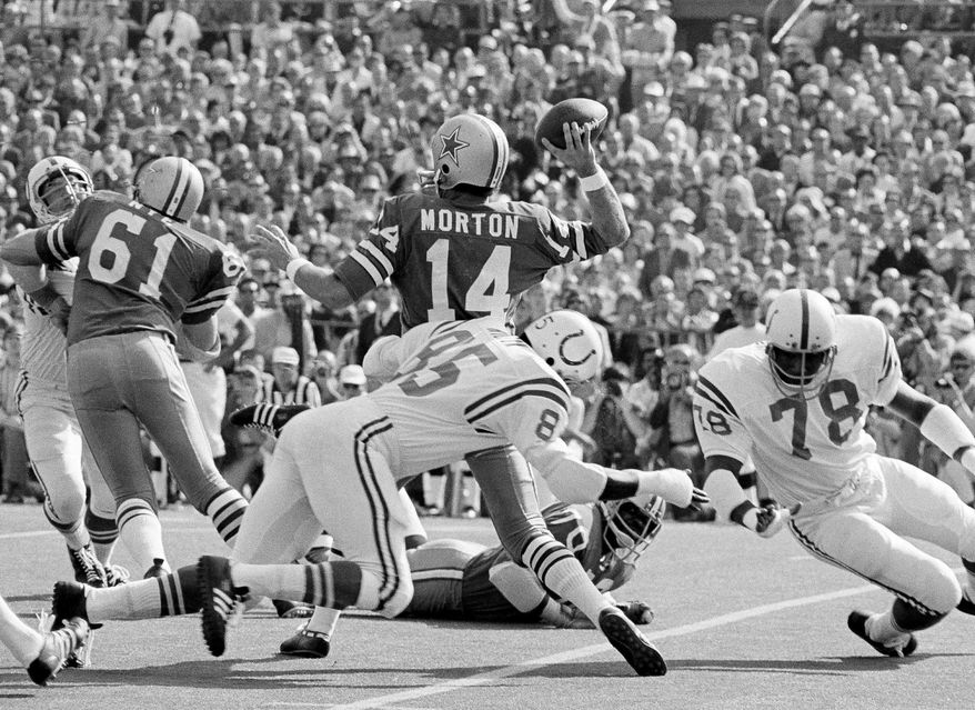 FILE - In this Jan. 17, 1971, file photo, Dallas Cowboys quarterback is hit from the rear by Baltimore Colts' Roy Hilton (85) in the first period of NFL football's Super Bowl in Miami, Fla. Peyton Manning will become only the third quarterback to start for two franchises in the Super Bowl. The first guy to do it, Morton, is among the thousands of former players suing the NFL about concussions. (AP Photo/File)