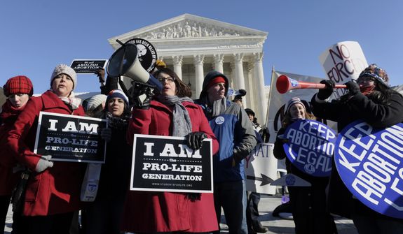 Pro-abortion and anti-abortion protestors rally outside the Supreme Court in Washington, Wednesday, Jan. 22, 2014, during the March for Life. Thousands of abortion opponents are facing wind chills in the single digits to rally and march on Capitol Hill to protest legalized abortion, with a signal of support from Pope Francis. (AP Photo/Susan Walsh)