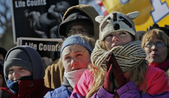 Anne Marie Duty, from Shawnee, Okla., right, joins other anti-abortion demonstrators as they rally during the annual March for Life, Wednesday, Jan. 22, 2014, on the National Mall in Washington. Thousands of anti-abortion demonstrators are gathering in Washington for an annual march to protest the Supreme Court&#x27;s landmark 1973 decision that declared a constitutional right to abortion. (AP Photo/Charles Dharapak)