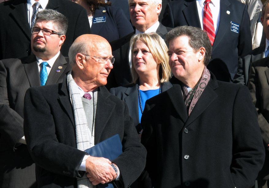 Kansas Sen. Pat Roberts, lower left, and Gov. Sam Brownback, lower right, participate in an anti-abortion rally outside the Kansas Statehouse, Wednesday, Jan. 22, 2014, in Topeka, Kan. Between them is state Sen. Mary Pilcher-Cook, chairwoman of the Senate Public Health and Welfare Committee. (AP Photo/John Hanna)