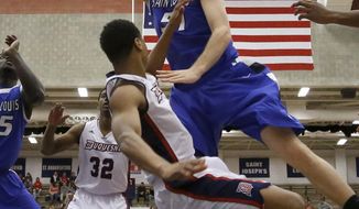 Saint Louis&#39; Rob Loe, top, draws a foul as he goes over Duquesne&#39;s L.G. Gill to shoot during the first half of an NCAA college basketball game Wednesday, Jan. 22, 2014, in Pittsburgh. (AP Photo/Keith Srakocic)