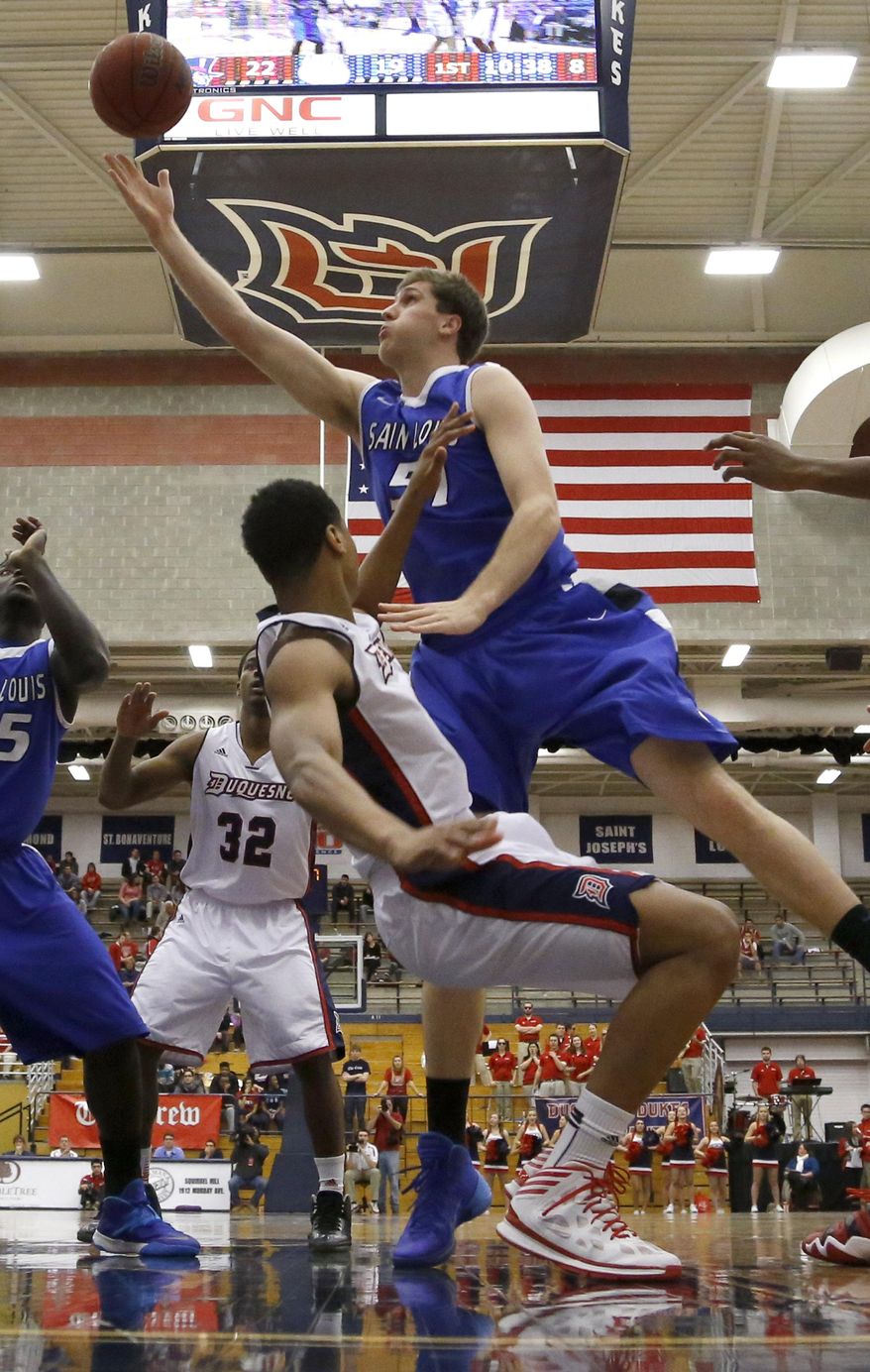 Saint Louis' Rob Loe, top, draws a foul as he goes over Duquesne's L.G. Gill to shoot during the first half of an NCAA college basketball game Wednesday, Jan. 22, 2014, in Pittsburgh. (AP Photo/Keith Srakocic)