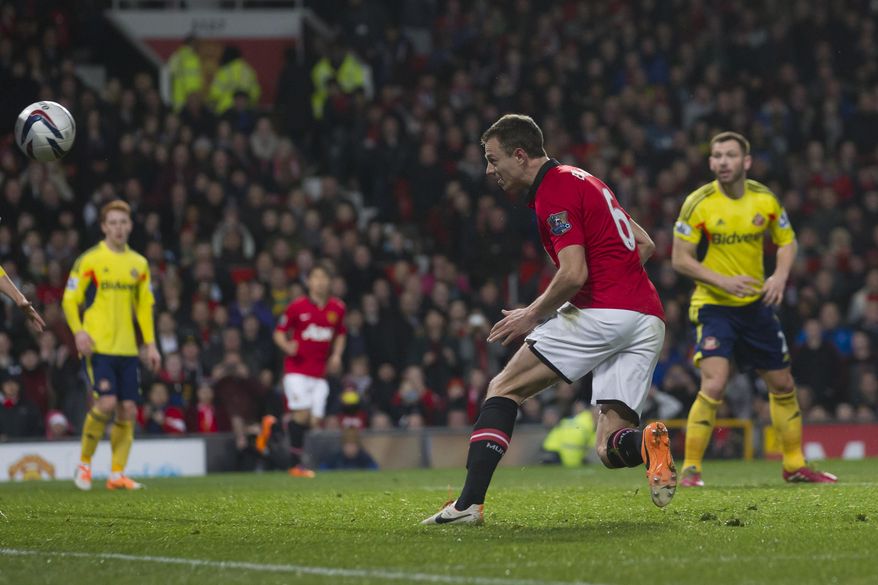 Manchester United's Jonny Evans, centre right, scores against Sunderland during their English League Cup semifinal second leg soccer match at Old Trafford Stadium, Manchester, England, Wednesday Jan. 22, 2014. (AP Photo/Jon Super)