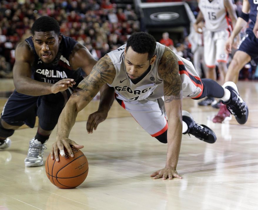 Georgia's Marcus Thornton, right, and South Carolina's Duane Notice (10) dive for a loose ball during the first half of an NCAA college basketball game Wednesday, Jan. 22, 2014, in Athens, Ga. (AP Photo/John Bazemore)