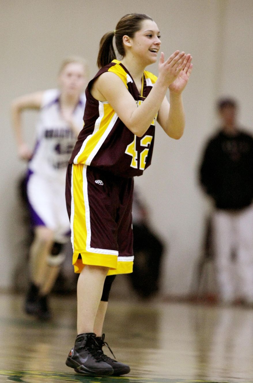In this Saturday, Feb. 26, 2011 photo, Harlowton-Ryegate's Dusty Taber claps after a made free throw by a teammate in the final minute of the Southern C divisional girls high school basketball championship game at Rocky Mountain College, in Billings, Mont. Taber, a 17-year-old senior, died in a car wreck on Sunday, Jan. 12, 2014. The accident occurred in Hill County on U.S. Highway 87 near Box Elder. Now, Taber's teammates are playing basketball to honor her. (AP Photo/The Billings Gazette, Paul Ruhter)