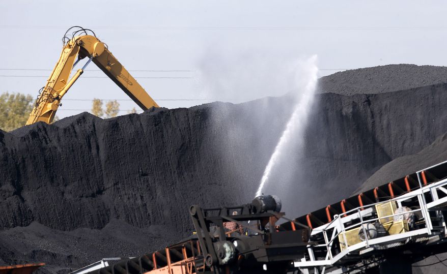 FILE - In this Oct. 25, 2013 file photo, petroleum coke, or petcoke, is watered down where it is stored along the Calumet River on Chicago's southeast side. The Pollution Control Board is scheduled to meet Thursday, Jan. 23, 2014, in Chicago to consider Gov. Pat Quinn's proposed emergency regulations for petroleum coke. Quinn says he's responding to complaints from Chicago residents that petroleum coke piling up on the city's southeast side is a health and environmental threat. (AP Photo/Charles Rex Arbogast, File)