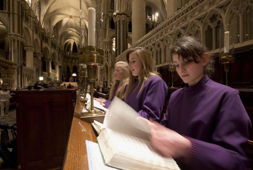 In this Wednesday, Jan. 22, 2014, photo, Choristers Chloe Chawner, right, Poppy Braddy, center, and Abby Cox look at their hymn books at Canterbury Cathedral, Canterbury, England, as the first all female choir at the cathedral rehearses prior to their debut on Jan. 25. (AP Photo/Alastair Grant) ** FILE **