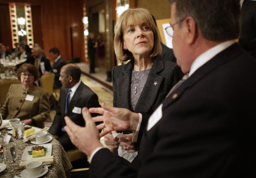 Massachusetts Attorney General Martha Coakley, center, speaks with University of Massachusetts President Robert Caret, right, before addressing a breakfast meeting of the Greater Boston Chamber of Commerce at a hotel, in Boston, Thursday, Jan. 23, 2014. The event is often a forum for politicians to offer new or revised policy initiatives. Coakley is running for Governor of the state. (AP Photo/Steven Senne)