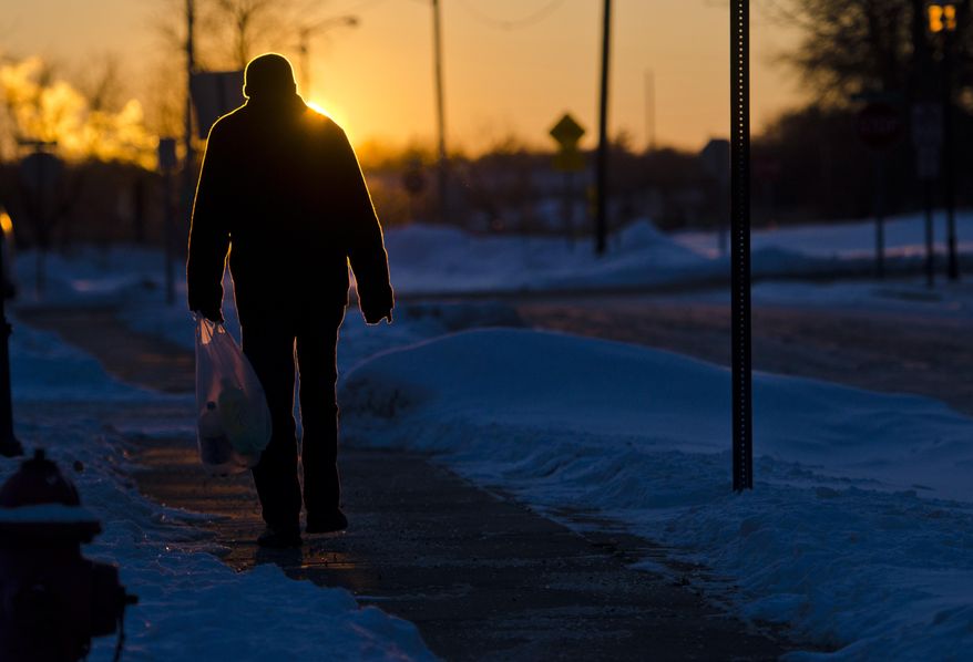 Larry Williams walks down Waters Street in Flint, Mich. into the sunset on his way to catch the bus on Thursday, Jan. 23, 2014. Local temperatures peaked at 13 degrees Fahrenheit on Thursday, and are expected to drop to -5 overnight. (AP Photo/The Flint Journal, Samuel Wilson) LOCAL TV OUT; LOCAL INTERNET OUT