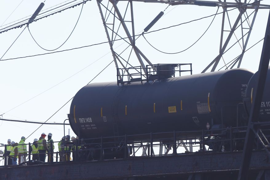 Railroad crews work on one of five derailed tank cars on a bridge over the Schuylkill River, Friday, Jan. 24, 2014, in Philadelphia. The accident Monday follows a series of derailments involving Bakken Shale crude from North Dakota including one that exploded in Canada, killing 47 people. (AP Photo/Matt Rourke)