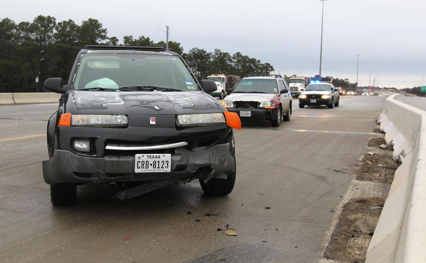 Steady rain Thursday led to icy road conditions as temperatures dropped Friday morning, Jan. 24, 2014 causing several accidents as motorists made their morning commute on I-45, in Conroe, Texas. (AP Photo/ The Courier, Jason Fochtman)