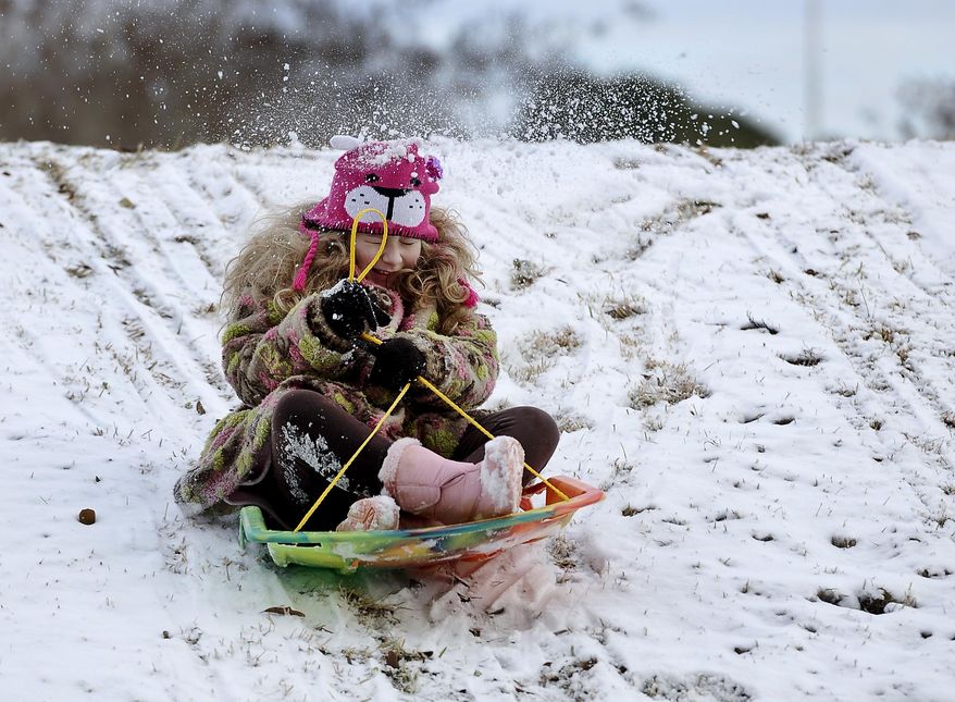 Hannah Wurtz, 9, gets a snowball in the back from her father, Gary Wurtz, not pictured, as she starts her sledding run Friday, Jan. 24, 2014, outside William R. Johnson Coliseum on the Stephen F. Austin State campus in Nacogdoches, Texas. A winter storm which moved across Texas on Thursday and into Friday dumped varying amounts of snow and caused school delays and cancellations across much of the region. (AP Photo/The Daily Sentinel, Andrew D. Brosig) MANDATORY CREDIT
