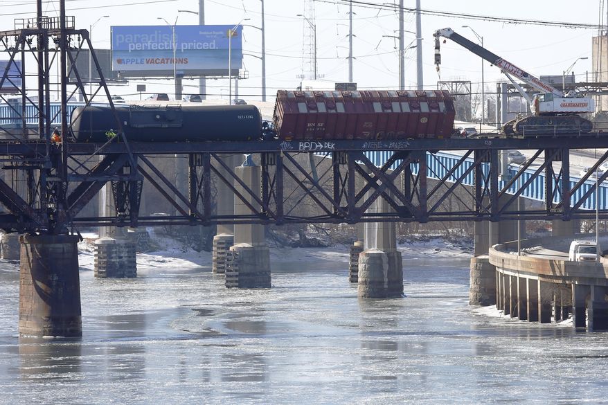 Railroad crews work on one of five derailed tank cars on a bridge over the Schuylkill River, Friday, Jan. 24, 2014, in Philadelphia. The accident Monday follows a series of derailments involving Bakken Shale crude from North Dakota including one that exploded in Canada, killing 47 people. (AP Photo/Matt Rourke)