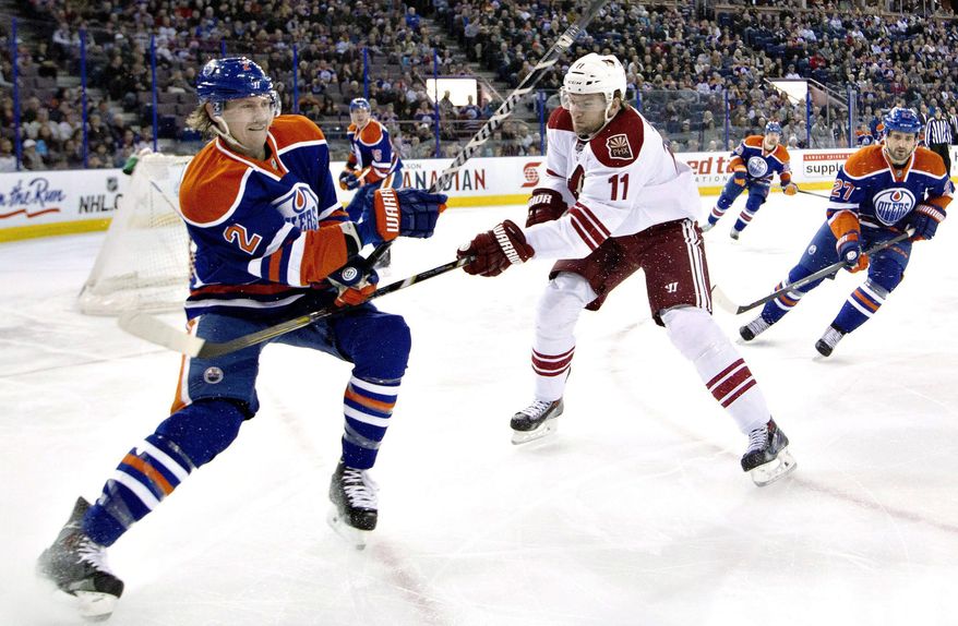 Phoenix Coyotes&#x27; Martin Hanzal (11) slashes Edmonton Oilers&#x27; Jeff Petry (2) as Oilers&#x27; Boyd Gordon (27) chases the puck during the first period of an NHL hockey game Friday, Jan. 24, 2014, in Edmonton, Alberta. (AP Photo/The Canadian Press, Jason Franson)